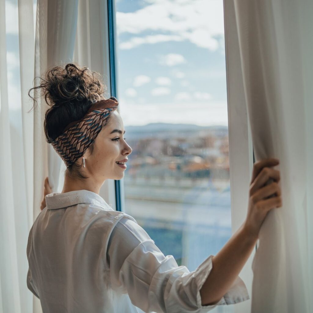 A woman looking out her window at home